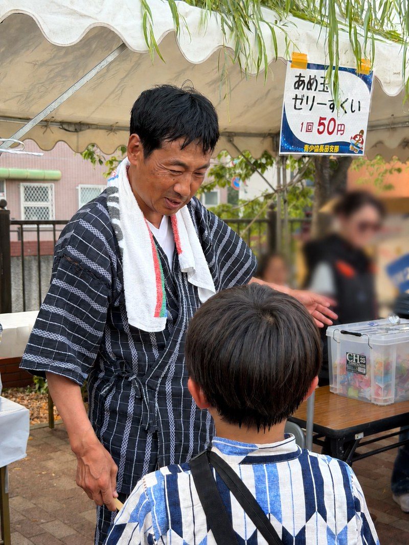地域のお祭りで子どもと話す川部宣宏（かわべのぶひろ）